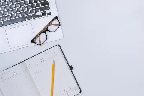 带日记和笔记本电脑的白色工作台