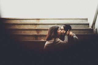 亲吻另一个女人脸颊的女人