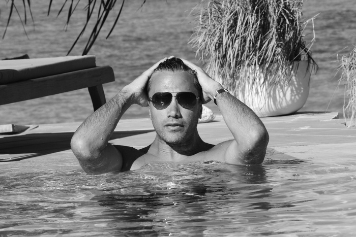 游泳池中男子的灰度照片