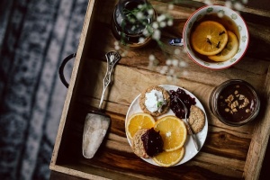 酒店早餐的客房服务托盘：饼干、果酱、巧克力慕斯、橘子水果、茶