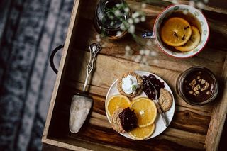 酒店早餐的客房服务托盘：饼干、果酱、巧克力慕斯、橘子水果、茶