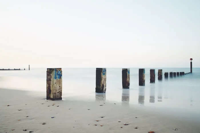 灰色天空下海边的灰色混凝土柱