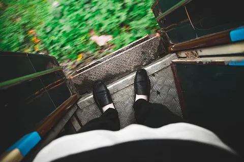 在缅甸,俯视着一列正在运行的火车的入口门边缘的双脚 在缅甸,俯视着一列正在运行的火车的入口门边缘的双脚