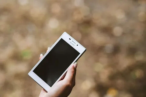 拿着白色手机的年轻女子