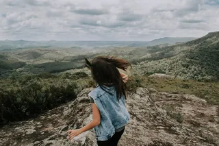 身穿蓝色牛仔背心的女士站立