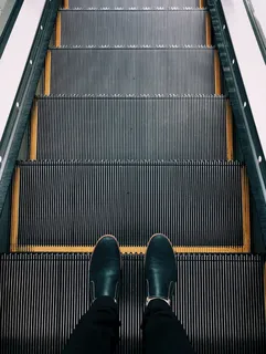 站在自动扶梯上的人