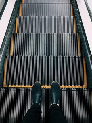 站在自动扶梯上的人