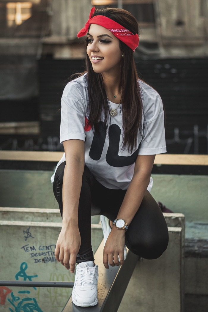 身穿白色T恤的女子蹲在灰色金属条上