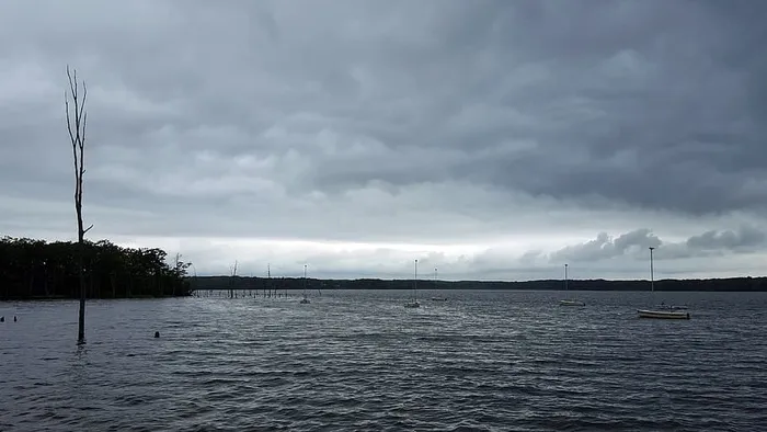 在暴风雨的天空下，帆船停泊在马纳斯坎水库的水面上。