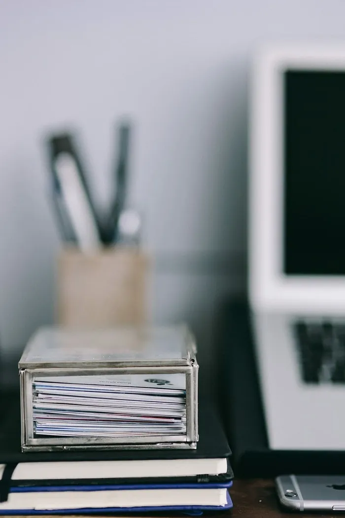 优雅的工作空间，配备Macbook、iPhone、名片和笔记本电脑