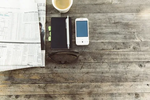 木质表面手机旁的钢笔