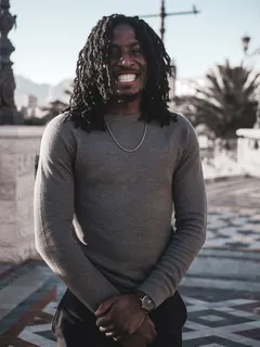 微笑男子穿着灰色长袖毛衣的照片