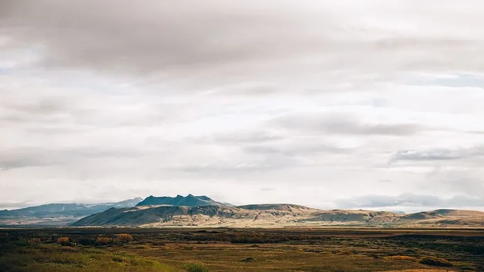 背景是群山的广阔田野上灰色多云的天空全景