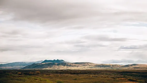 背景是群山的广阔田野上灰色多云的天空全景 背景是群山的广阔田野上灰色多云的天空全景