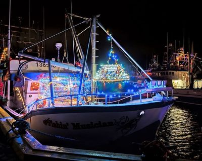加拿大纽芬兰和拉布拉多德格雷夫港——2017年12月22日。2017年12月22日，在德格雷夫港拍摄的夜晚用灯光庆祝圣诞节的渔船。