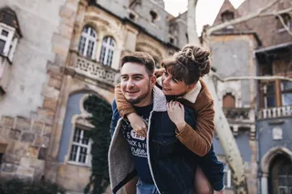 一名男子在大楼附近让一名女子倒车