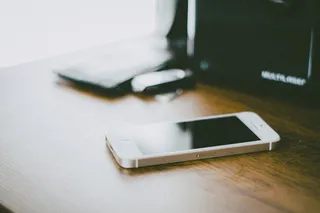 棕色木质表面的金色iPhone 5s