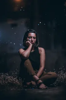 坐在白色椅子上的女人右手放在脸颊上