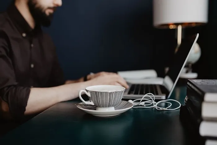 男性用笔记本电脑和一杯咖啡工作