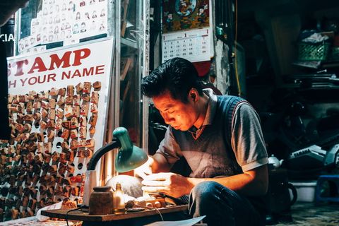 男子将手持工具放在带灯的桌子上