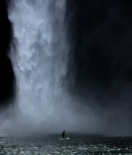 瀑布附近穿着白色挡板的男子