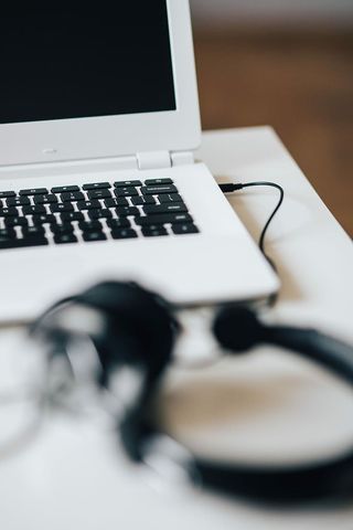 带智能手机和耳机的白色笔记本电脑