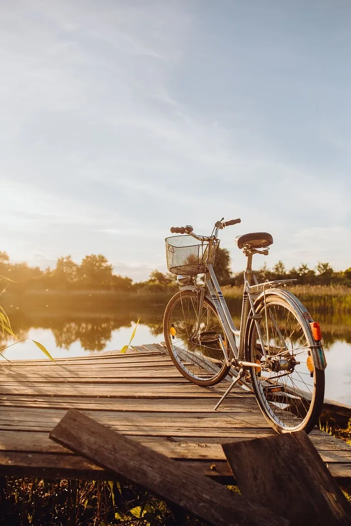 在明亮的夕阳下，在码头上放着篮子的自行车