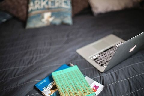 床上有书的笔记本电脑