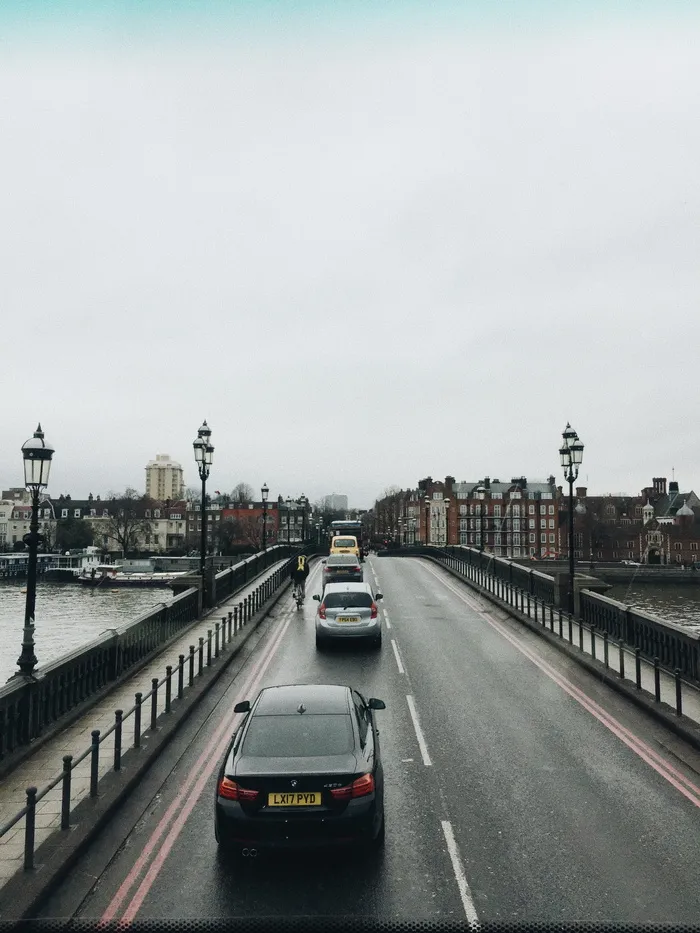 所有车辆在道路左车道行驶，而在灰色天空下，右车道空无一人
