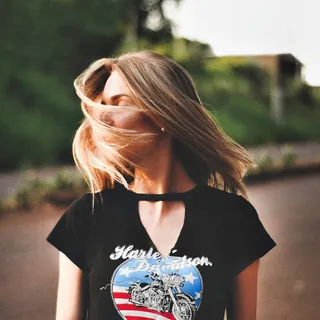 身穿黑色哈雷戴维森衬衫、脸上留着头发的女人
