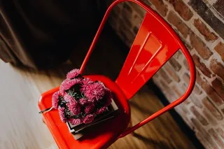 工业用金属椅子，上面有一束粉红色的花和书