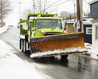 暴风雪前，铲雪车在道路上撒盐。