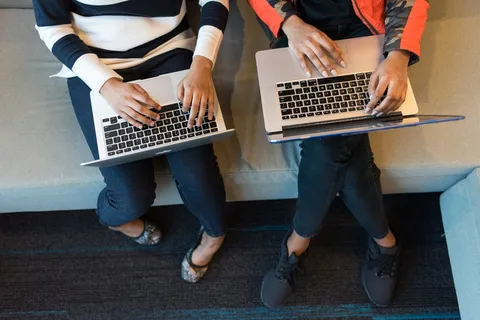 两个人拿着Macbook Pro 两个人拿着Macbook Pro