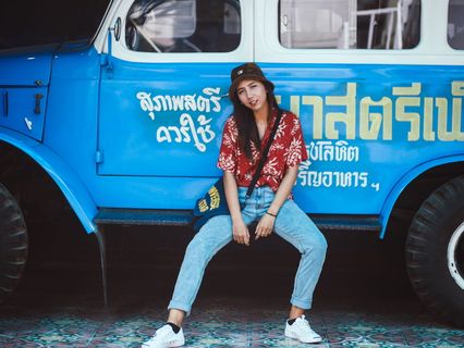 女子坐在蓝色卡车侧踏板上的照片