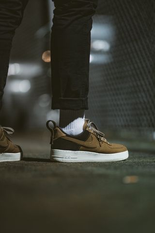 穿着棕色和黑色Nike Air Force 1的站立人员