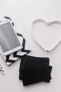 黑白笔记本和带有各种物品的白色智能手机