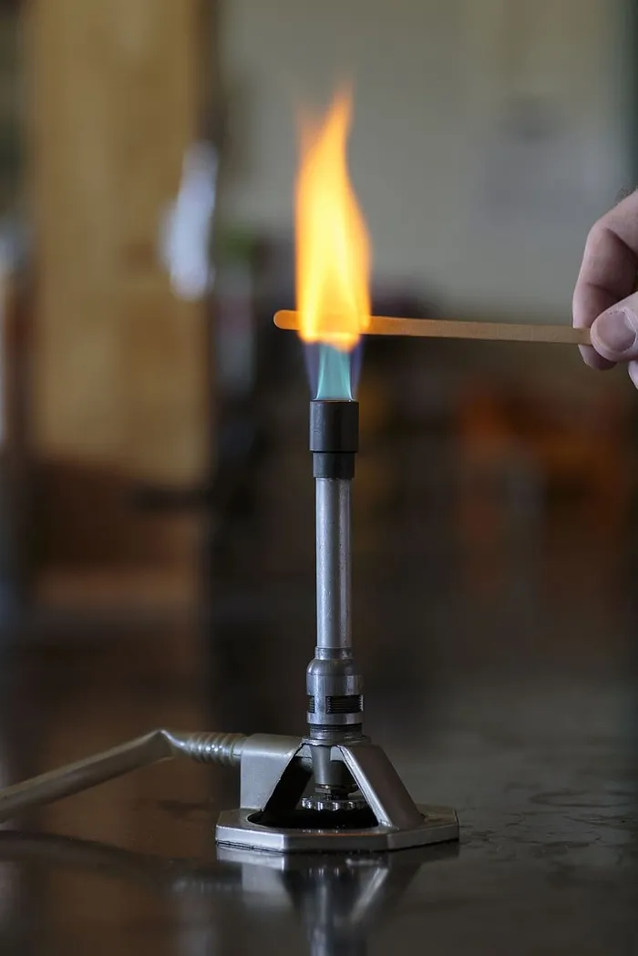 钠溶液在本生灯火焰中的木夹板上燃烧。