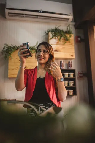 在分体式空调附近使用镜子的女性