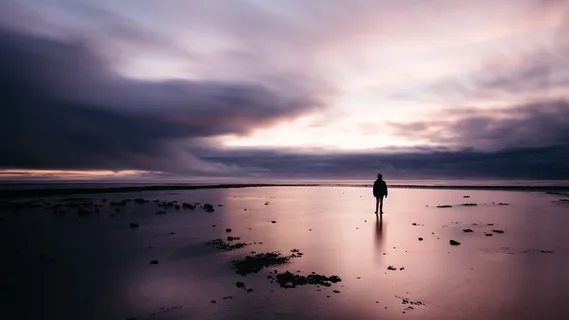 黑暗天空下站在沙滩上的男人
