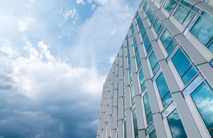 漂亮的带窗户的办公大楼。雨后蓝天白云