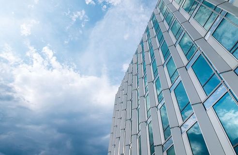漂亮的带窗户的办公大楼。雨后蓝天白云