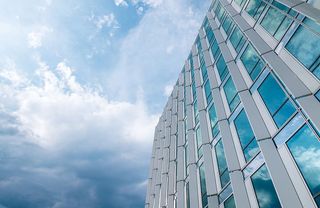 漂亮的带窗户的办公大楼。雨后蓝天白云