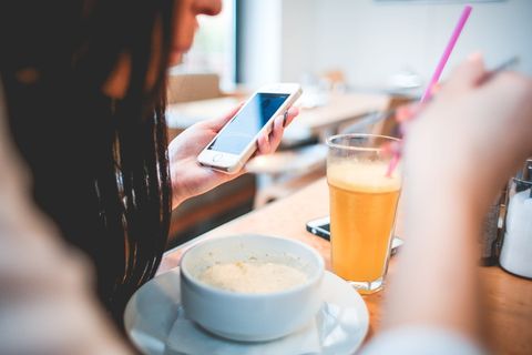 人类拿着电话在前面的白色圆碗