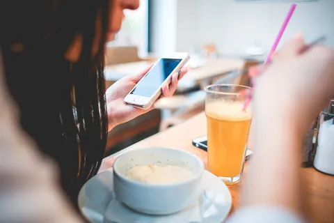 人类拿着电话在前面的白色圆碗