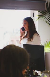 手持黑色智能手机的女性对面的人