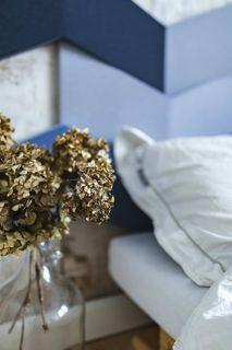 设计师卧室，床边的罐子里放着一株金色的装饰植物