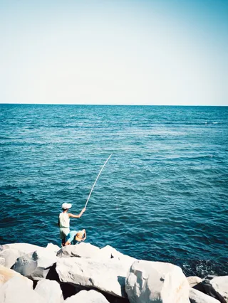 两个男孩站在巨石上钓鱼