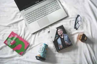 MacBook和带眼镜书的平面摄影