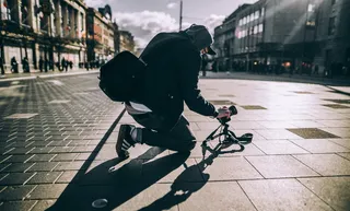person kneeling on floor taking photo with sunlight