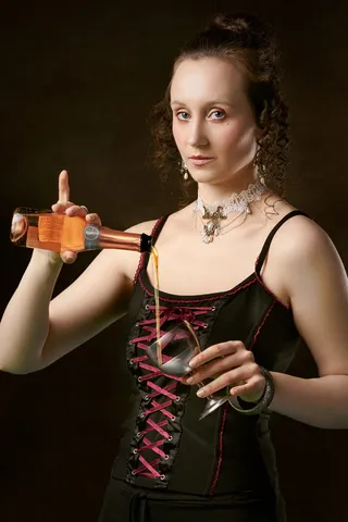 女人在杯子上倒葡萄酒